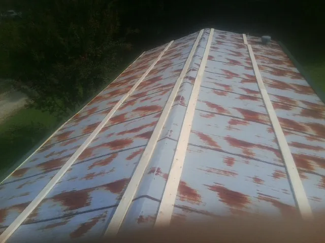 Rusted metal roof panels with new wood purlins before replacement — Storm Damage Roof Repair in Manchester by Roofing Brothers